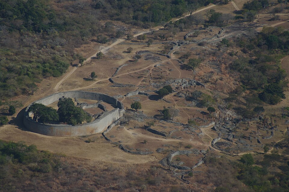 Grand Zimbabwe, monument de Bâtisseurs shona anonymes : Vastes murailles elliptiques en pierre sèche, avec une haute enceinte courbe et des…