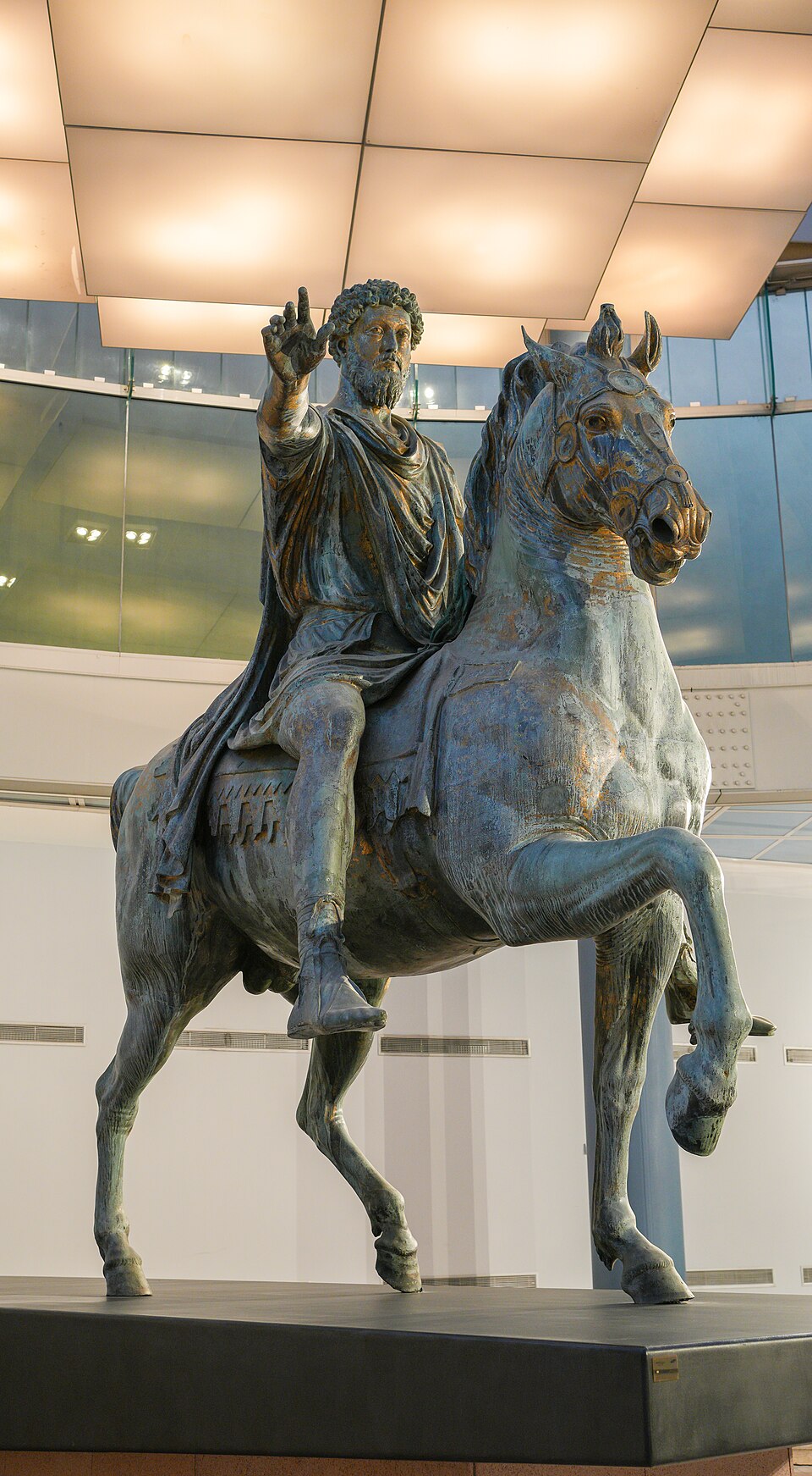 La statue équestre de Marc Aurèle, sculpture de Sculpteur romain anonyme : L’empereur à cheval tend le bras droit, dans une pose solennelle et…