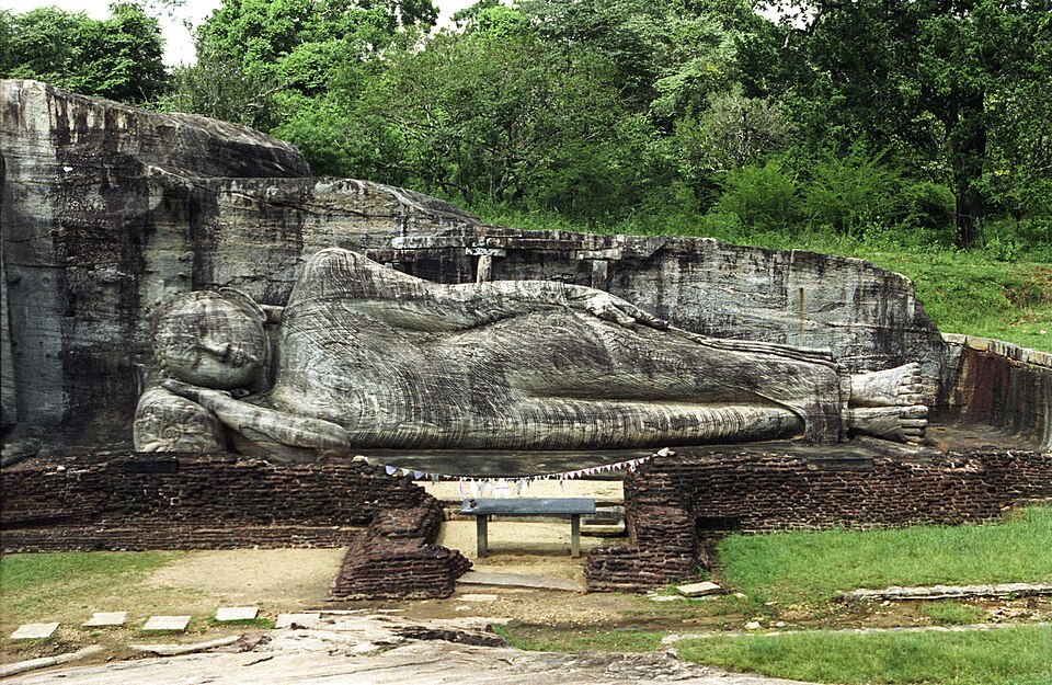 Le Bouddha couché de Gal Vihara, sculpture de Sculpteurs cinghalais anonymes : Un Bouddha monumental repose sur le côté, les yeux clos, taillé…