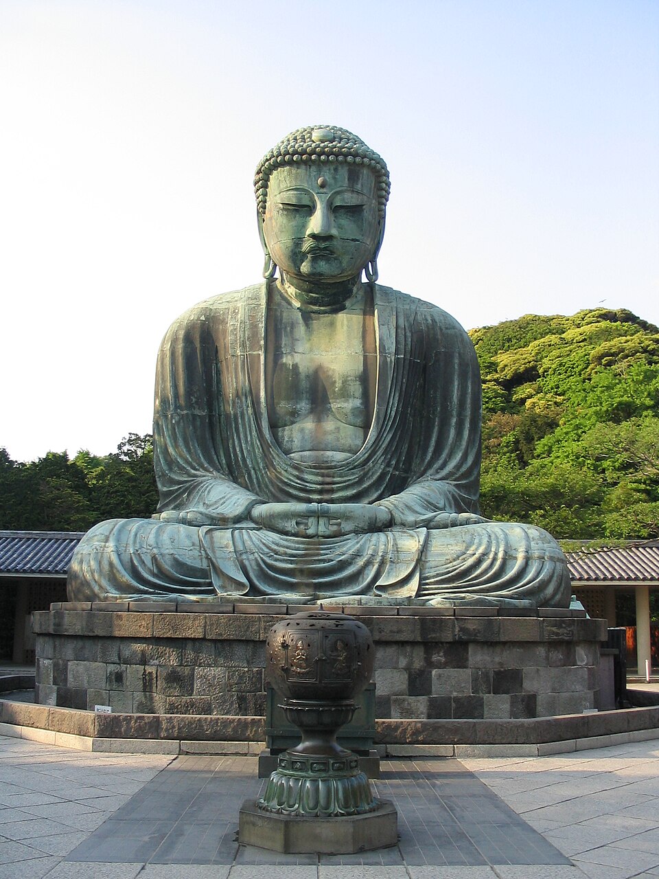 Le Grand Bouddha de Kamakura, sculpture de Sculpteurs japonais anonymes : Une immense statue de Bouddha en bronze, assise en méditation, domine…