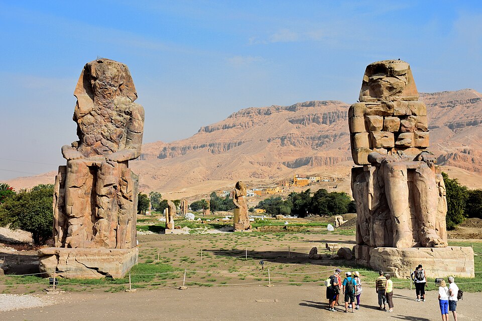 Les Colosses de Memnon, sculpture de Sculpteurs égyptiens anonymes, commandités par Amenhotep III : Deux statues géantes assises représentent un…